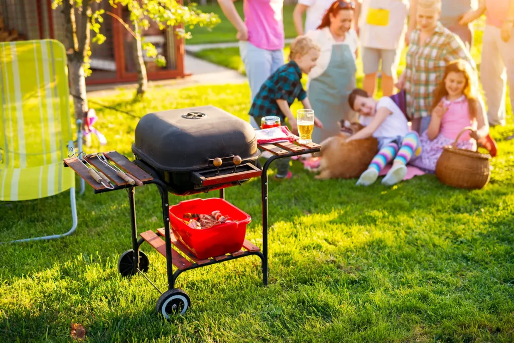 Want A Dog POOP FREE Yard This Spring? A family spending together, playing with the dog, and having a barbeque in the backyard.